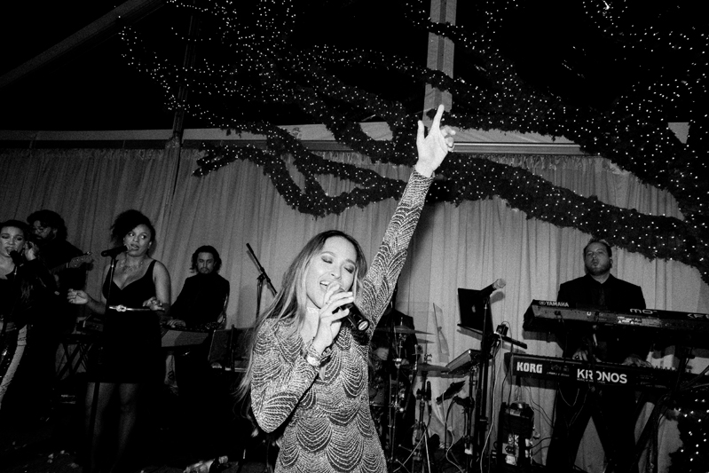 Powerhouse band vocalist on stage during wedding reception.
