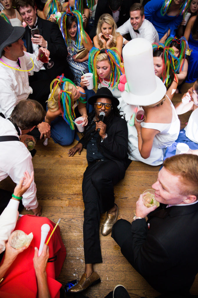 Punch lead singer surrounded by wedding guests on dance floor.