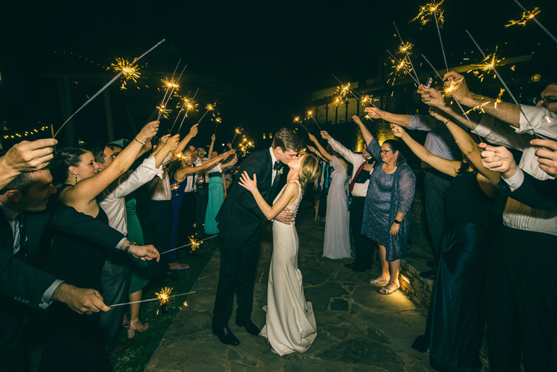 bride and groom kissing during sparkler exit