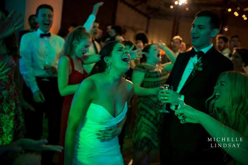 Bride laughing and signing on dance floor with Modern Luxe band.