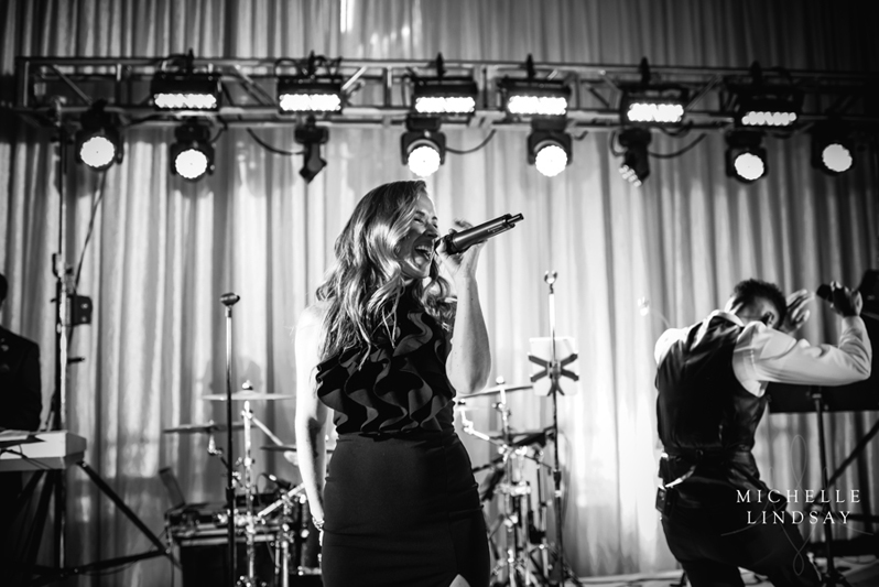 Modern Luxe vocalist onstage performing at wedding reception.