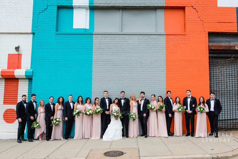 Bridal party in front of colorful wall