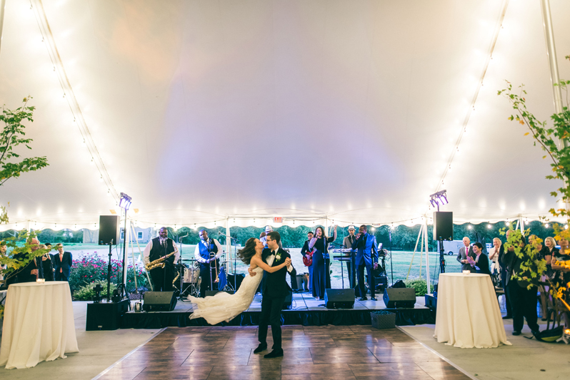 Groom swinging bride on dance floor during Summerfield Farms wedding reception.