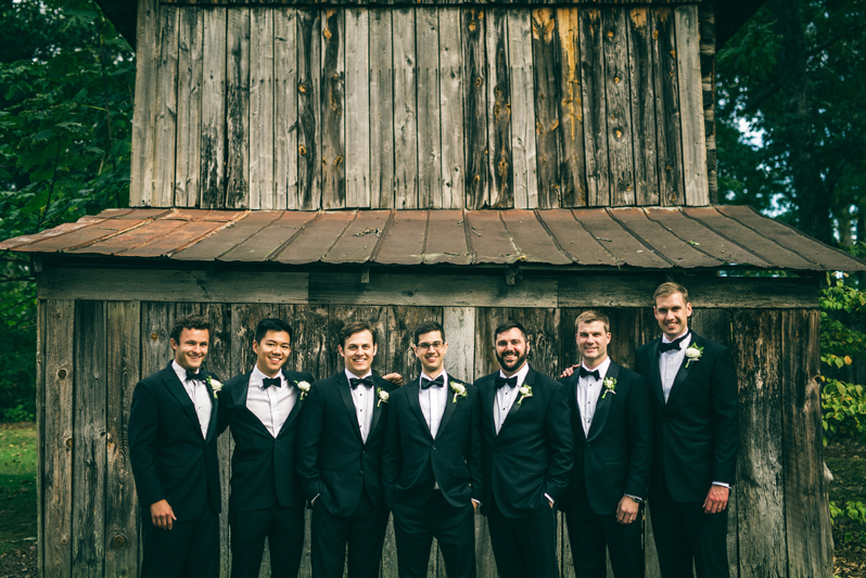 Groom and groomsmen in front of barn at Greensboro wedding.