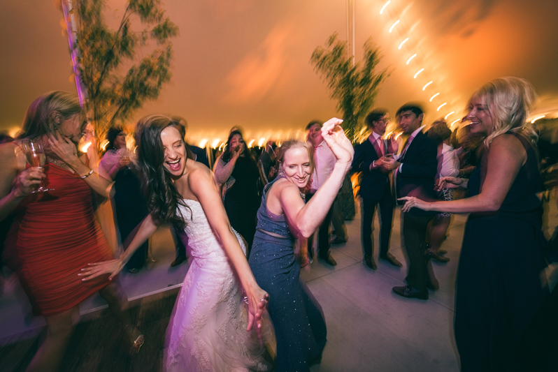 Bride and woman dancing at wedding reception at Summerfield Farms. 