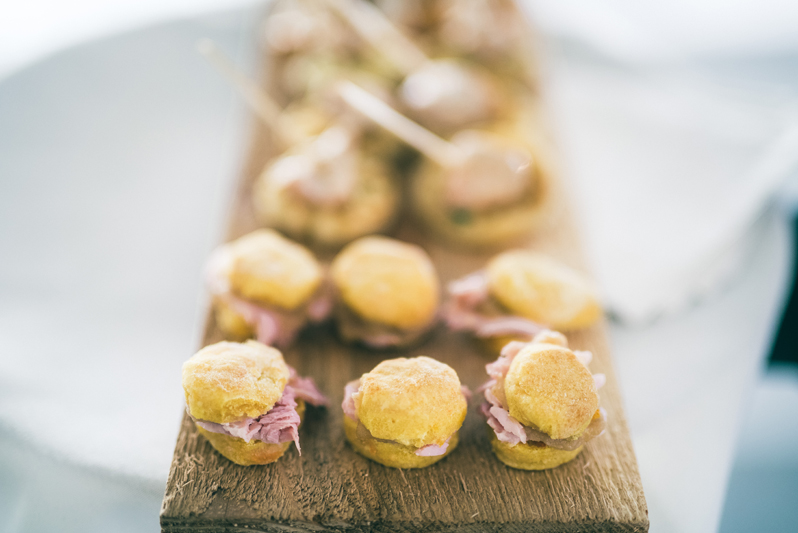Ham biscuits displayed on wooden cutting board at Summerfield Farms wedding reception.