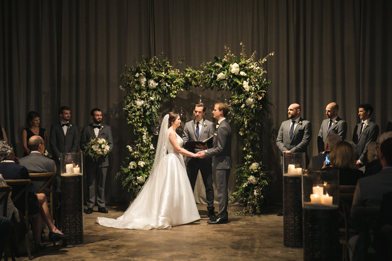 Couple getting married in front of pastor during wedding ceremony.