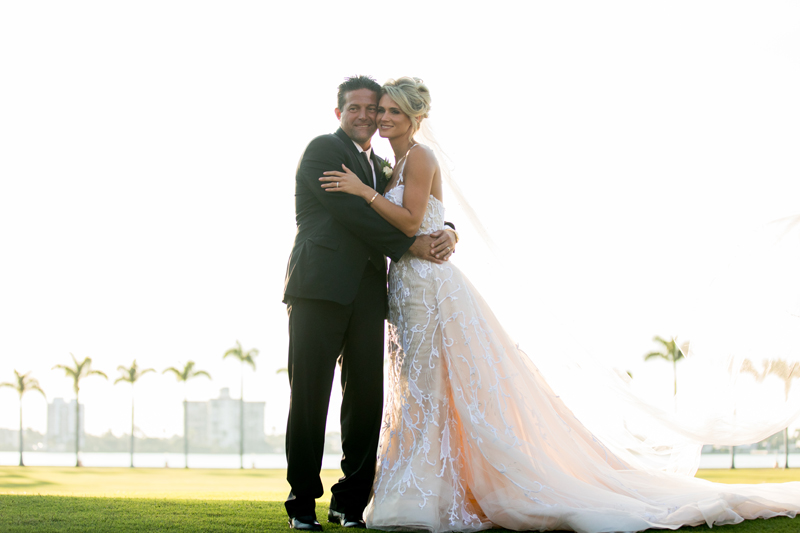 Bride and groom posing outside Mar-a-Lago during Palm Beach wedding.