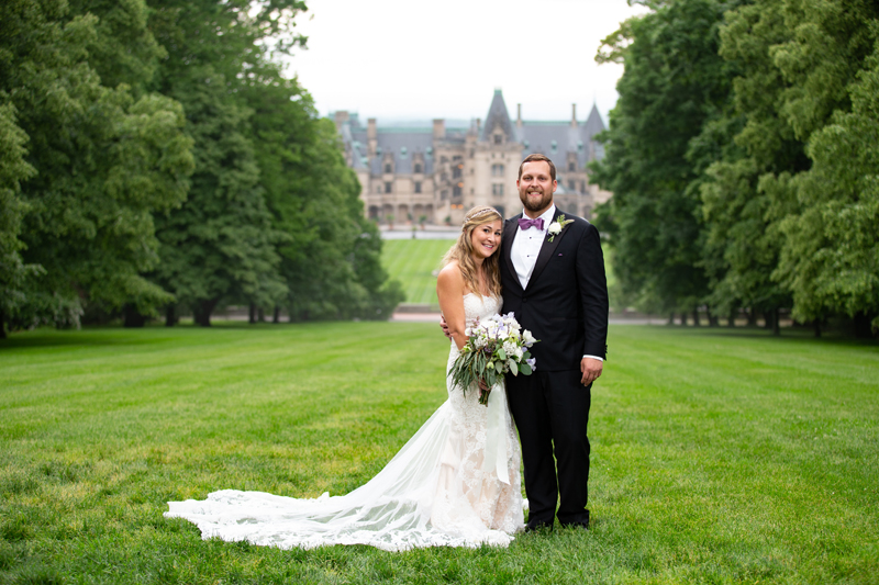 Bride and groom posing in front of Biltmore Estate.