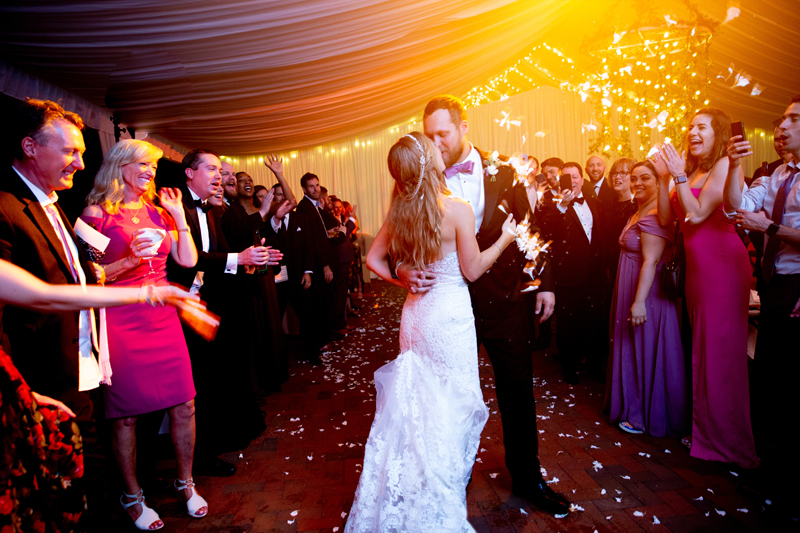 Bride and groom kissing as they exit Biltmore wedding reception.