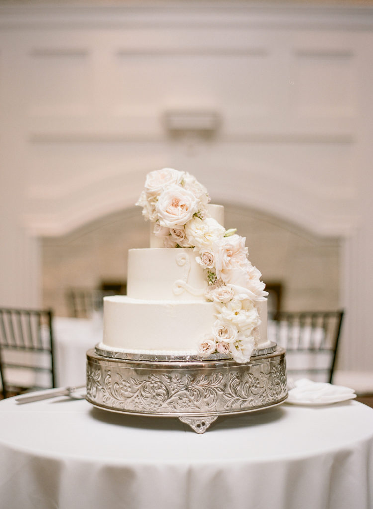 Three tiered wedding cake with cascading flowers.