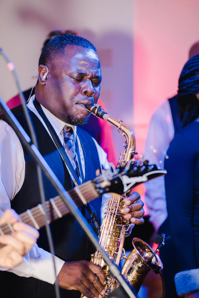 Sax player performing at Bride and groom dancing The Hora at Jewish wedding at Chesapeake Bay Beach Club wedding reception.