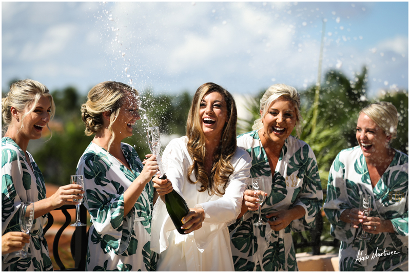 Bride popping bubbly with bridesmaids before Palm Beach wedding