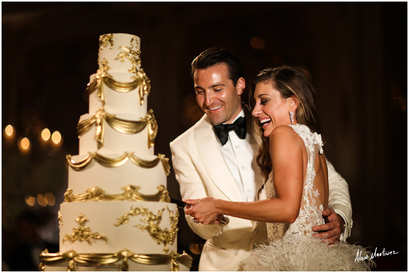 Bride and groom cutting five tiered wedding cake during Mar-A-Lago wedding reception