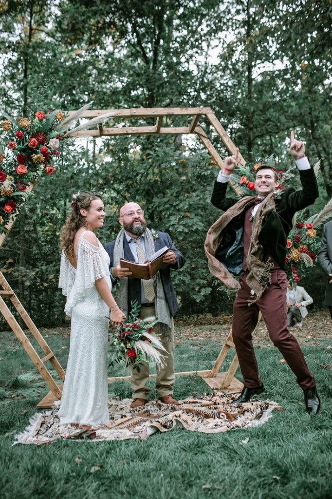 Bride, groom and officiant during outdoor Bohemian style wedding